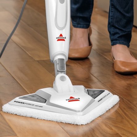A stick sweeper cleaning hardwood floors. Links to a blog post about floorcare that's best for hardwood floors including sweepers and vacuums for hard floors.