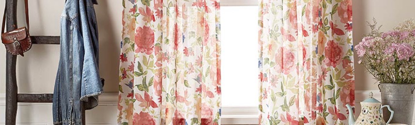 A set of floral curtains in a window. Starts the window treatment ideas blog post on dailysavesonline.com.