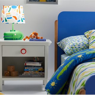 A kids bedroom designed by Drew Barrymore with alligator bedding and a fun blue bed frame.